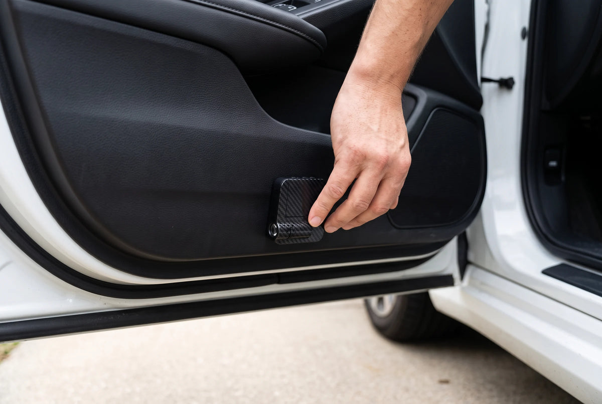 A hand mounting the compact projector on the inside of a white car door