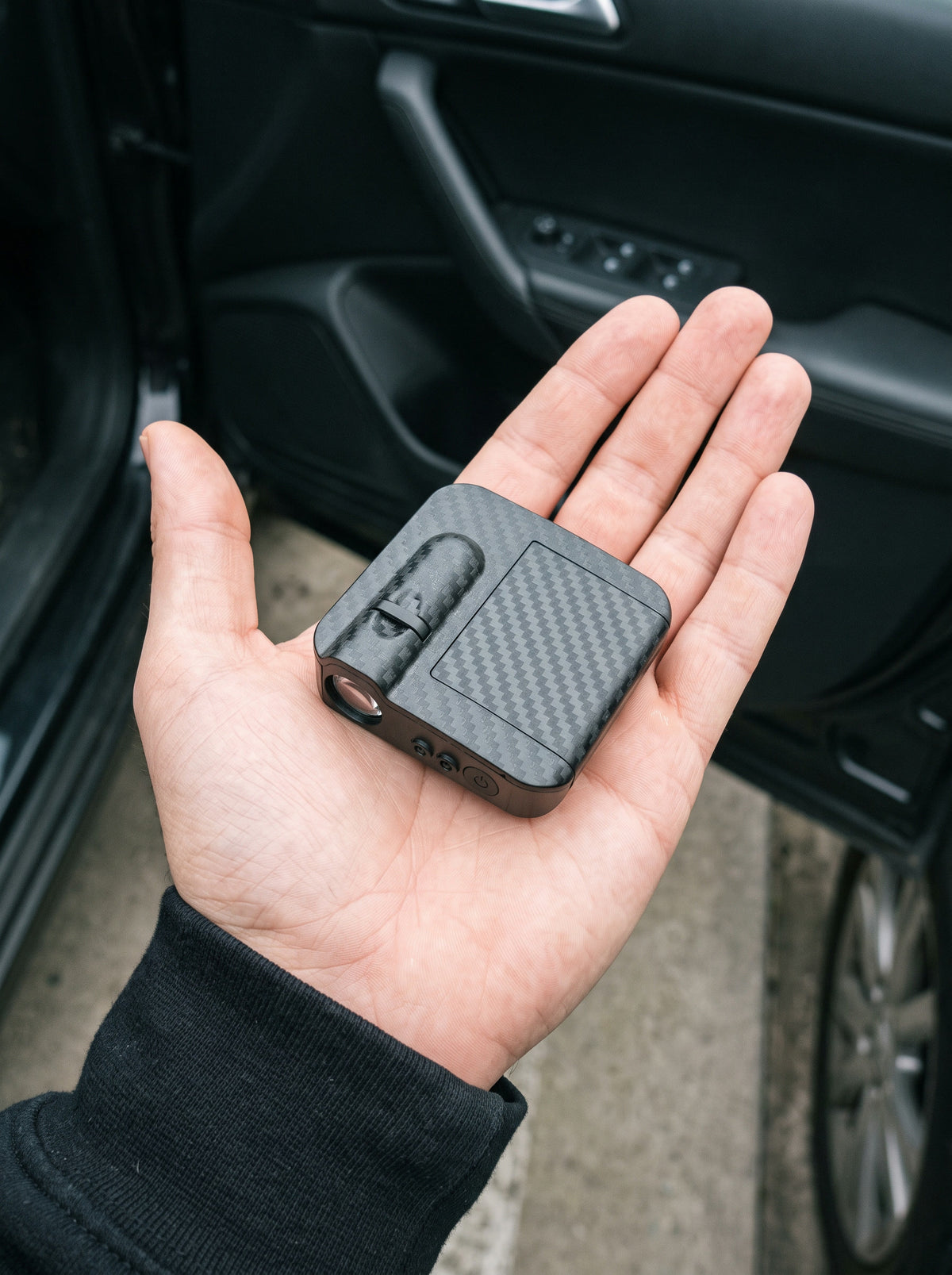 The AzerGlow projector in the palm of a hand, showing its size